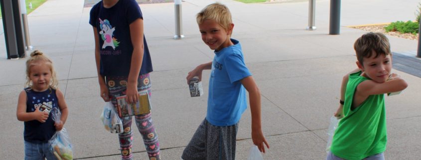 a group of 4 children pose as super heroes in the Joplin Library Entryway