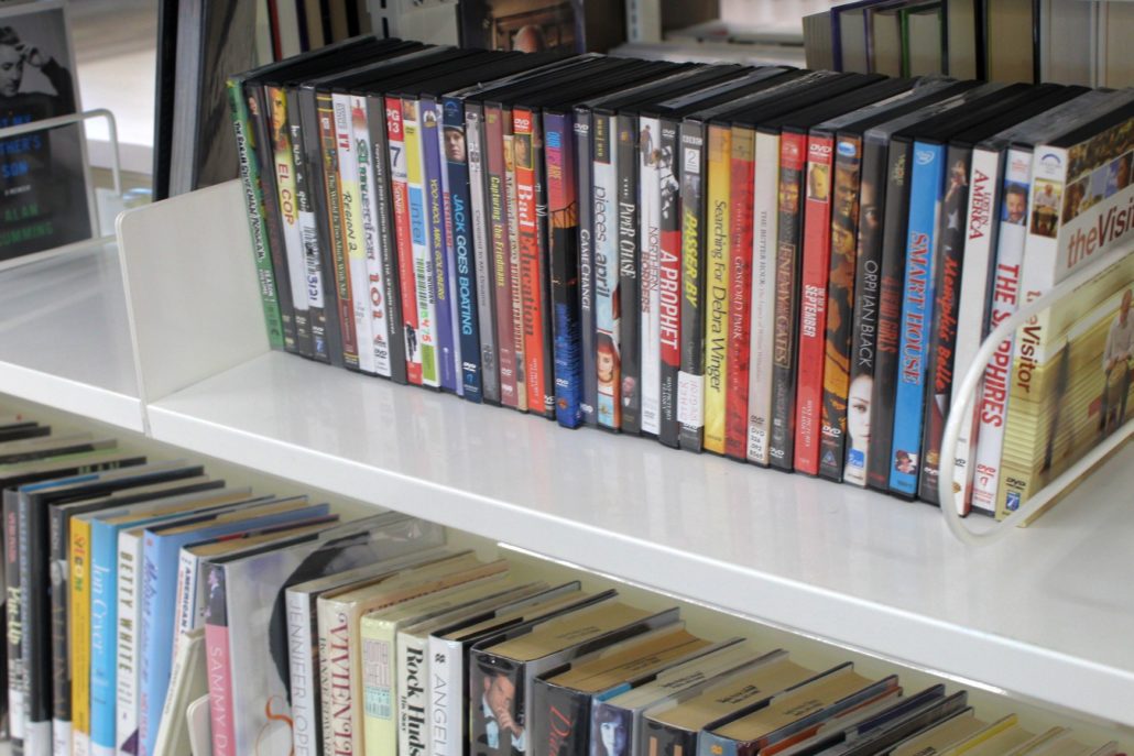 A row of DVDs is arranged neatly on a shelf.