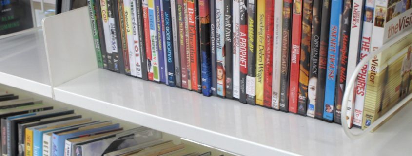 A row of DVDs is arranged neatly on a shelf.